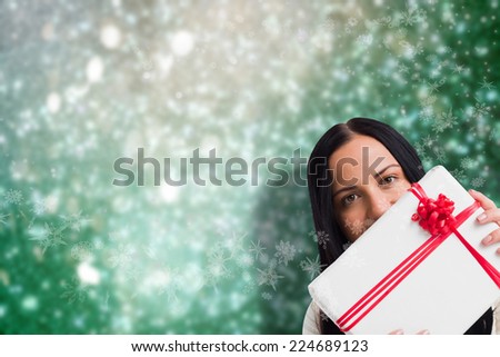 Woman holding a large present against blurred lights