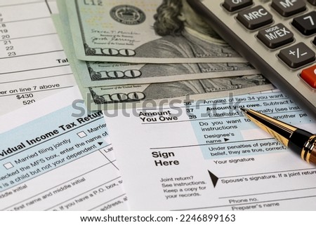 Amount you owe line on income tax return forms, cash money and calculator. Federal tax return, income tax, tax refund and payment concept Royalty-Free Stock Photo #2246899163