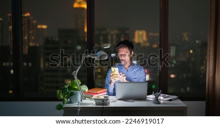 Asian business man sitting in office using laptop and smartphone for work Royalty-Free Stock Photo #2246919017