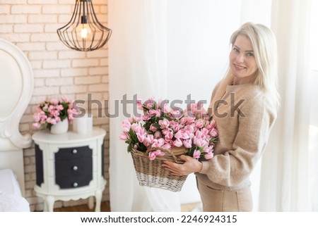 Young and elegant woman holding a flower basket with spring flowers