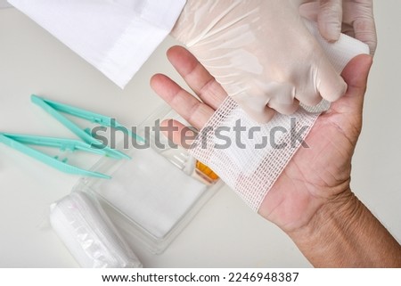 Doctor doing wound dressing care and bandaging patient's hand, Hand surgery treatment, Nurse treat patient's finger injury in hospital. Royalty-Free Stock Photo #2246948387