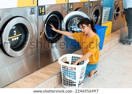Asian people using qualified coin operated laundry machine in the public room to wash their cloths. Concept of a self service commercial laundry and drying machine in a public room. Royalty-Free Stock Photo #2246956497