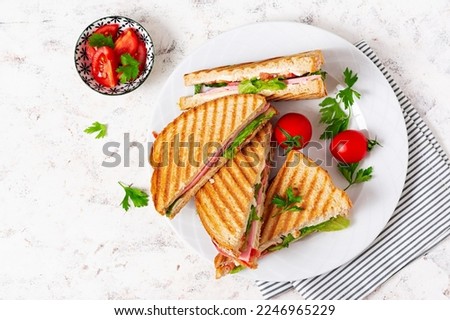 Club sandwich panini with ham, tomato, cheese and lettuce. Top view Royalty-Free Stock Photo #2246965229