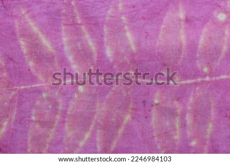 Texture background of natural yellow leaf from eco print process. Colorful Eco-printing on pink fabric background.