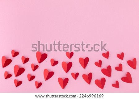 Border of various red hearts on pink background for Saint Valentine day greeting card or banner. 
