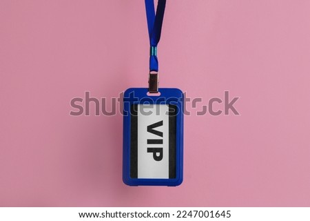 Plastic vip badge hanging on pale pink background