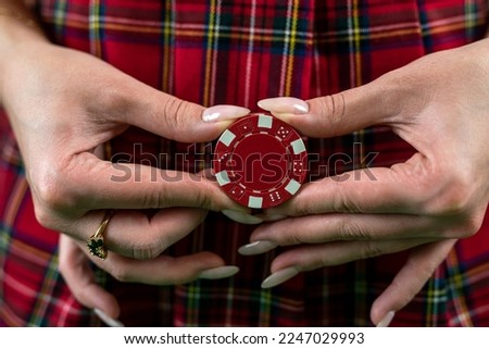 girl shows in front of her a colored poker red chip in her hands. Poker. casino. isolated on plain background
