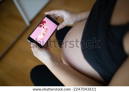 Pregnant female watching 3d animation of her fetus on the smartphone