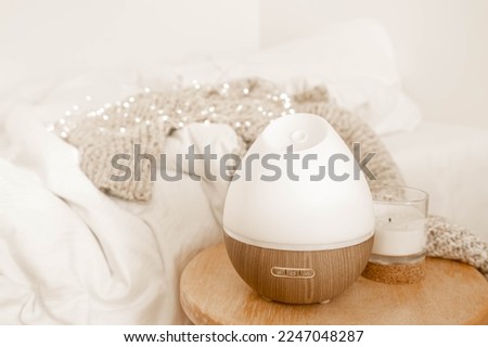 A composition with an aroma diffuser and a candle in the interior of the room.