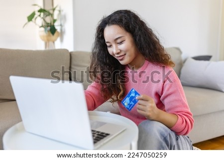 Female consumer spending buying on internet, lifestyle. Happy Asian woman shopping online with laptop at home. Woman using laptop computer shopping on line, using credit card playing online