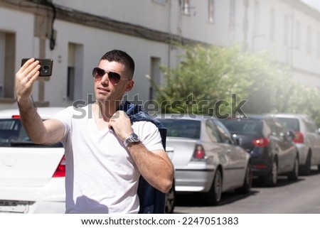 casual man with mobile phone and sunglasses taking a selfie