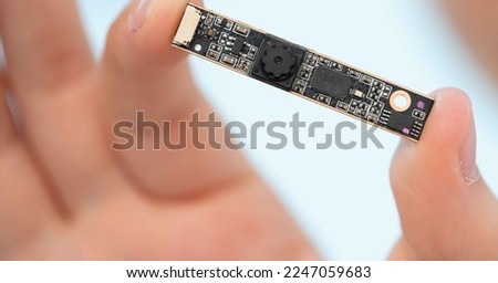 girl holds in her hands a miniature video camera for covert video surveillance systems Royalty-Free Stock Photo #2247059683