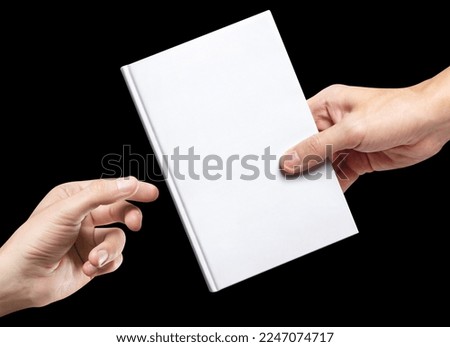 Hands sharing white hardcover book, isolated on black background Royalty-Free Stock Photo #2247074717