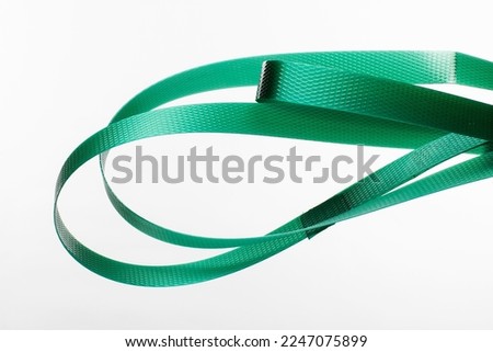 Nylon cord strap for industrial use isolated on white background, close up plastic poly strap for cargo box. Composite cord strapping belt for securing a transport Royalty-Free Stock Photo #2247075899