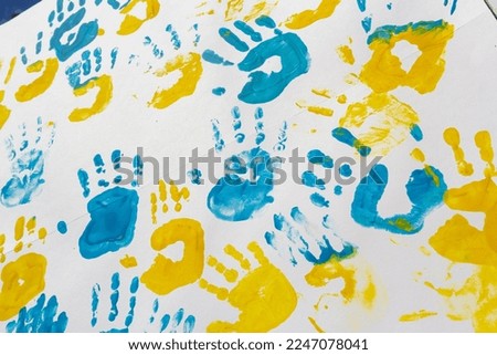 bright prints of children's hands from paint on the wall, background, texture, horizontal format.