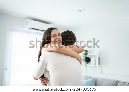 Caucasian young man and woman hugging each other in living room at home. Attractive romantic new marriage couple male and female spend time celebrate anniversary and valentine's day together in house. Royalty-Free Stock Photo #2247093695