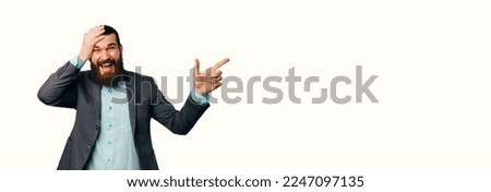 Banner photo size of amazed young man with beard in casual suit pointing away at copyspace isolated on white
