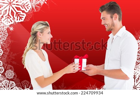 Young couple with gift against christmas themed snow flake frame