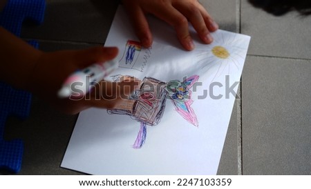 Little Girl drawing a cat with a colored pen. 