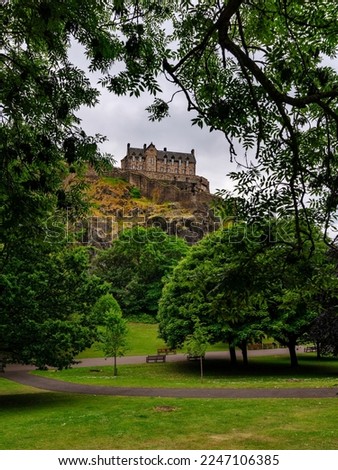 Edinburgh Castle view for the Princes Street gardens with cloudy sky. Scotland.