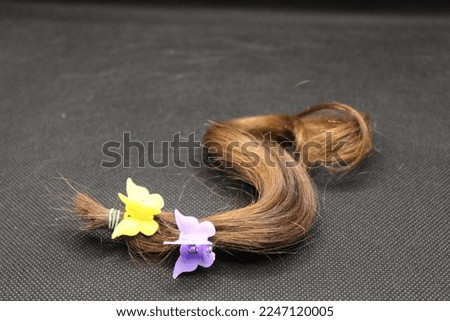 Butterfly clips on piece of hair Royalty-Free Stock Photo #2247120005