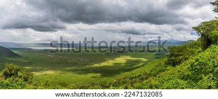 Stunning panoramic scenery of Ngorongoro Crater in Tanzania with clouds and rain showers in the distance