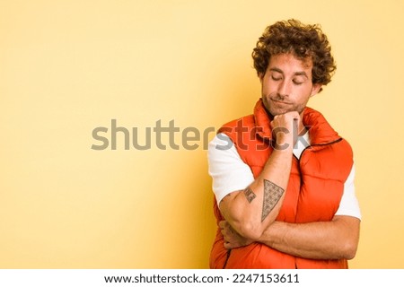 Young smart caucasian man on yellow background looking sideways with doubtful and skeptical expression. Royalty-Free Stock Photo #2247153611