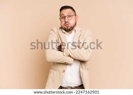 Adult latin business man cut out isolated blows cheeks, has tired expression. Facial expression concept.