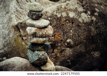 Pyramid of stones in the mountains. Cairn making by tourists. Abstract rock construction.