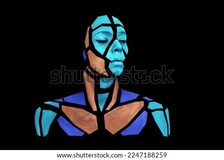 Portrait of a human with creative art makeup posing in the studio. Shape of colorful polygons on beautiful face, neck and shoulders. Parts of face isolated on black background.