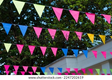 Colorful small flags hanging on the rope for holidays, fun party decoration concept.