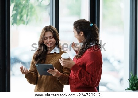 Friends using smartphone and having coffee in a coffee shop Royalty-Free Stock Photo #2247209121