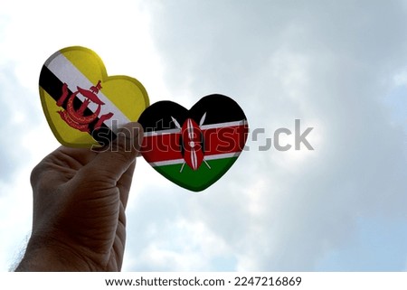 Hand holds a heart Shape Brunei and Kenya flag, love between two countries