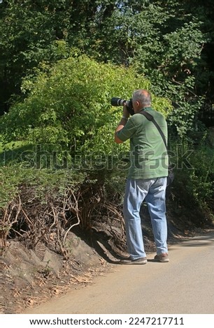 Adult male paparazzi taking a photo shoot