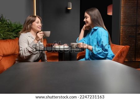Young women with coffee spending time together in cafe