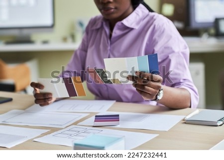 Close up of black young woman as creative designer holding color swatches in office, copy space
