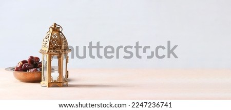 Muslim lamp and dates on light background with space for text
