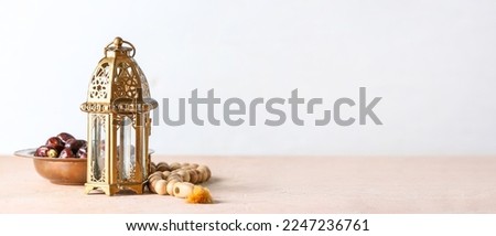 Muslim lamp and tasbih with dates on light background with space for text Royalty-Free Stock Photo #2247236761