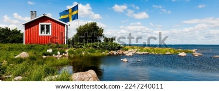 Red house in Sweden with flag Royalty-Free Stock Photo #2247240011