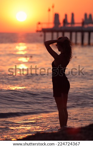 Girl says goodbye to the sea at sunset