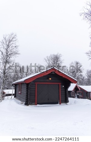 Beautiful little wooden mountain houses, huts surrounded by forest on a sunny winter day. Skiing resort in Sweden, Funasdalen covered in snow