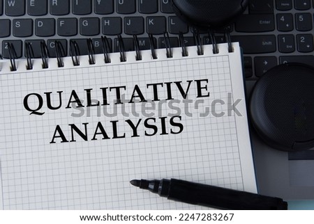 QUALITATIVE ANALYSIS - words on a white sheet on the background of a computer keyboard and headphones. Info concept Royalty-Free Stock Photo #2247283267