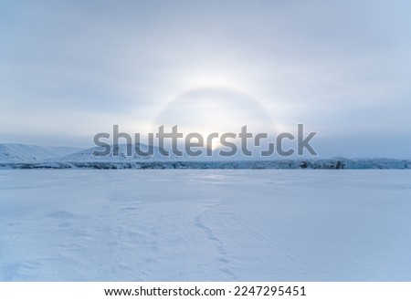 Winter arctic landscape. Snow-covered tundra. Snowy ground surface. Cold frosty winter weather. The harsh climate of the polar region. Endless arctic desert. Royalty-Free Stock Photo #2247295451