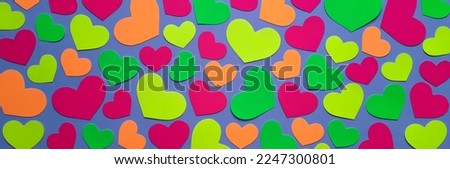 Banner with origami hearts. Flat lay. Website template for February, valentine's day, mother's day. Pink, yellow, orange and green paper hearts on a bright blue background. Top view. Theme of love.