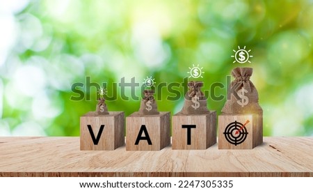 Wooden blocks with the words VAT target icon and money bag and coins, Taxes payment concept, Tax evasion, Taxation, Business and finance, Financial planning.