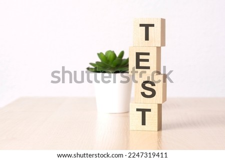 word TEST with wood cubes, white background