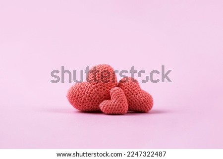 Croched pink hearts on a pink background. Valentine's Day, symbol of love.