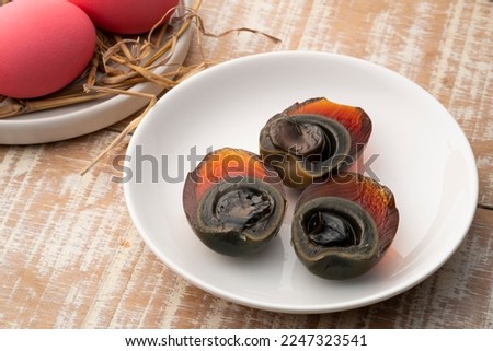 Half sliced Century egg in white plate, Pink color preserved eggs. Royalty-Free Stock Photo #2247323541