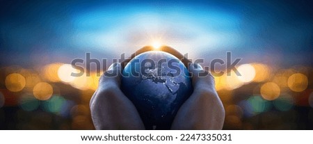 The globe Earth in the hands of man against the night city. Concept on business, politics, ecology and media. Earth day abstract background. Elements of this image furnished by NASA. Royalty-Free Stock Photo #2247335031