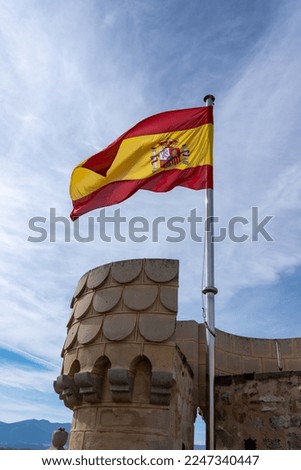 View of the Spanish Flag on top of Castle with Blue skies in the background
